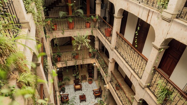 A multi-level atrium with balconies, potted plants, and seating areas.
