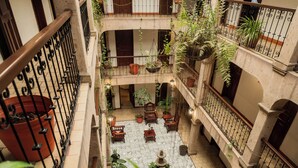 A multi-level atrium with balconies, potted plants, and a central fountain.