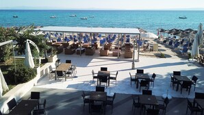 Un restaurante frente al mar con terraza, zona cubierta y vistas al océano.