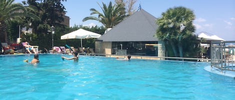 Piscine extérieure, parasols de plage, chaises longues