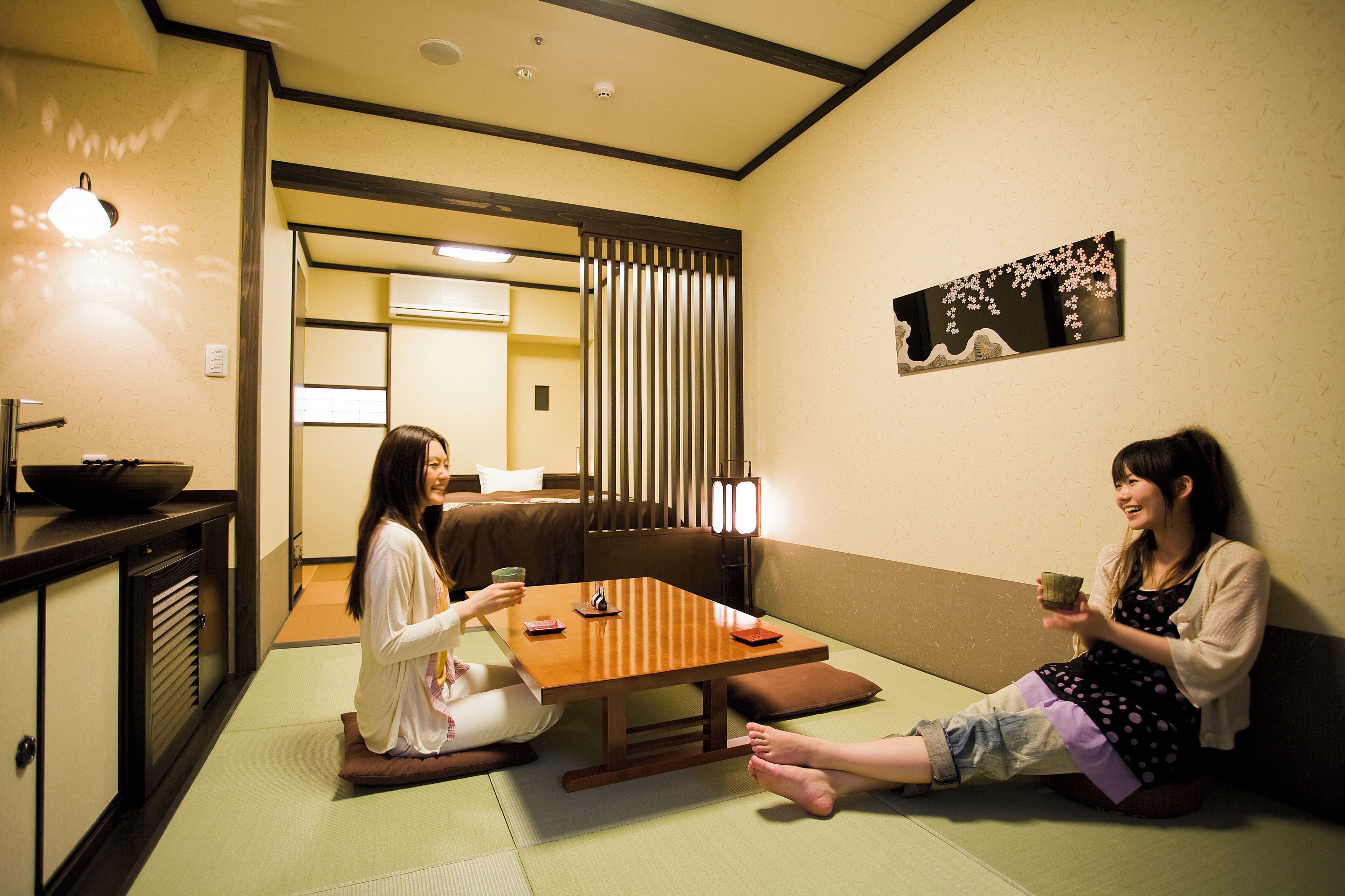 Una habitación tradicional japonesa con suelo de tatami, una mesa baja y un puertas correderas.