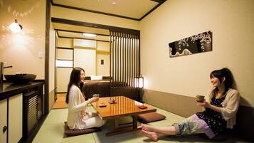 Una habitación tradicional japonesa con suelo de tatami, una mesa baja y un puertas correderas.