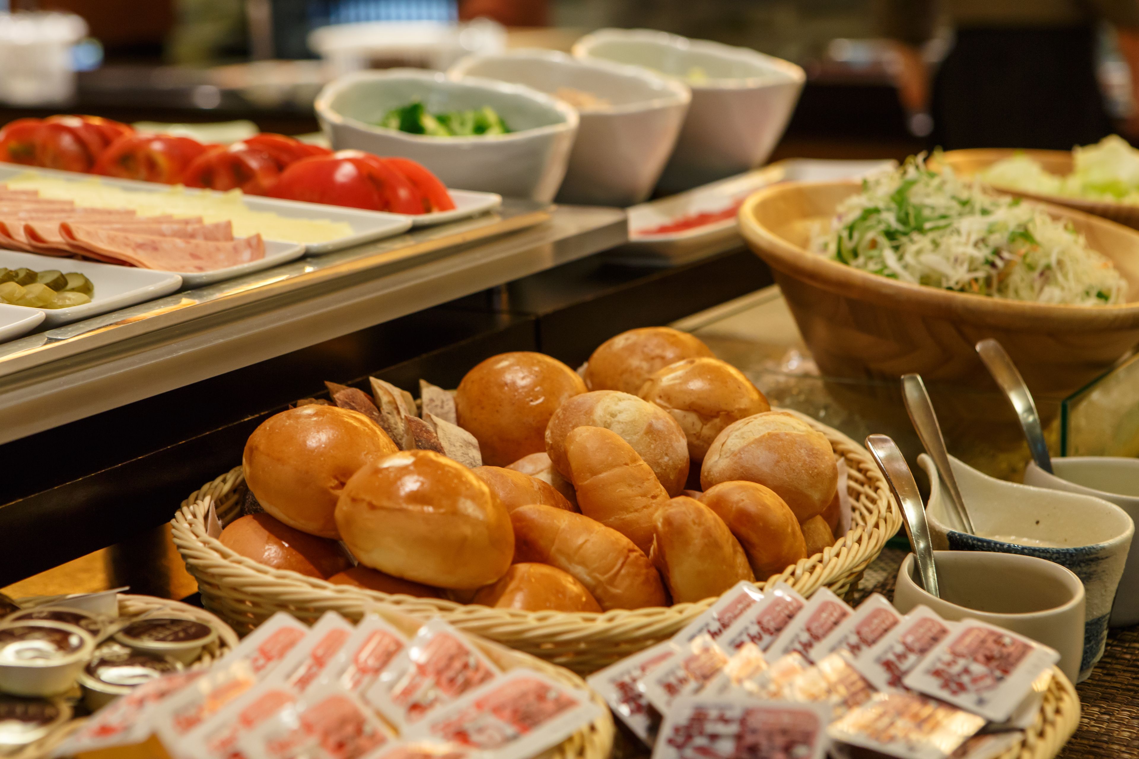 A buffet with various food items including bread, salads, and condiments.