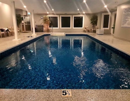 Una piscina techada, sillones reclinables de piscina