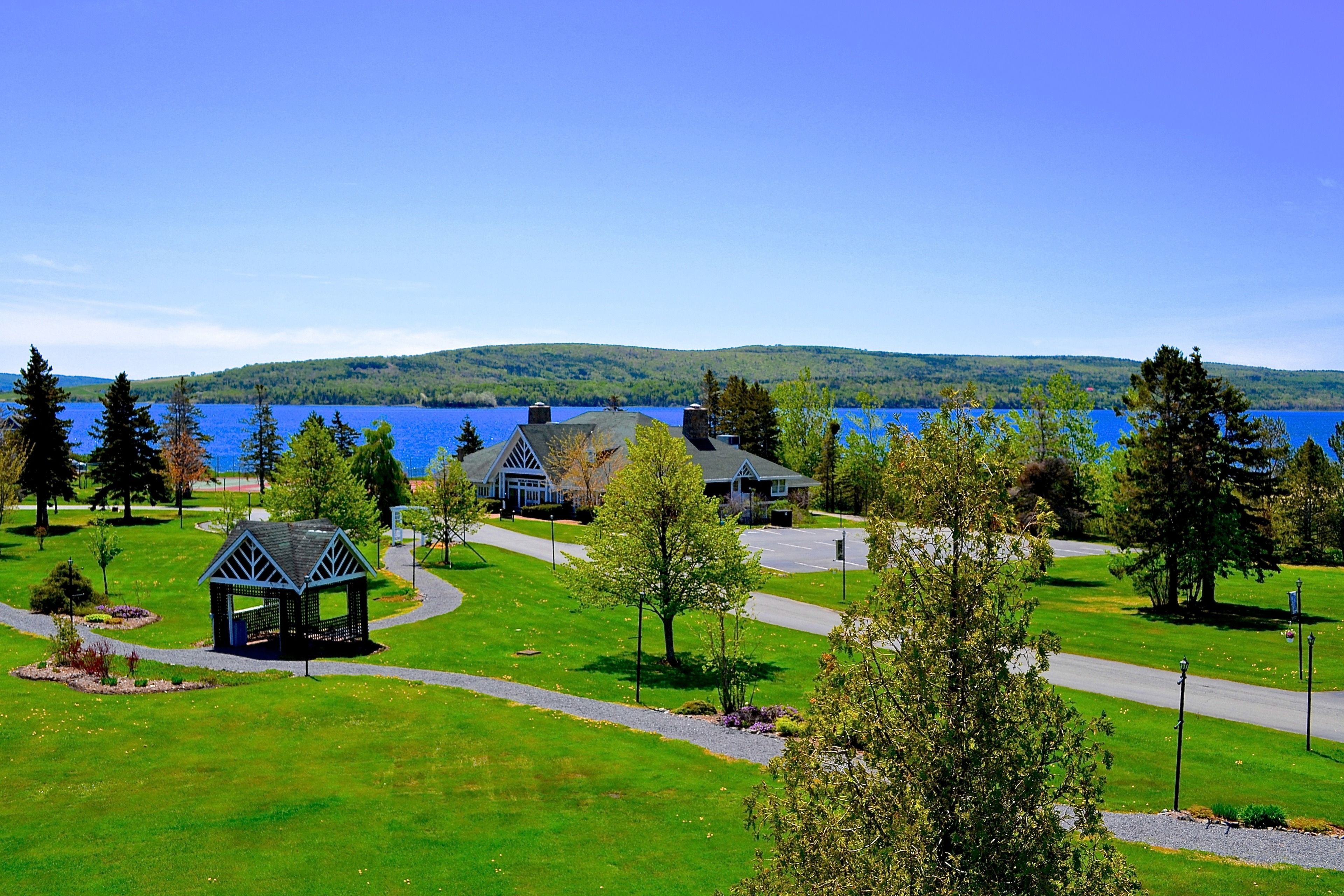 A lakeside property with a gazebo, a house, and a clear view of the lake.