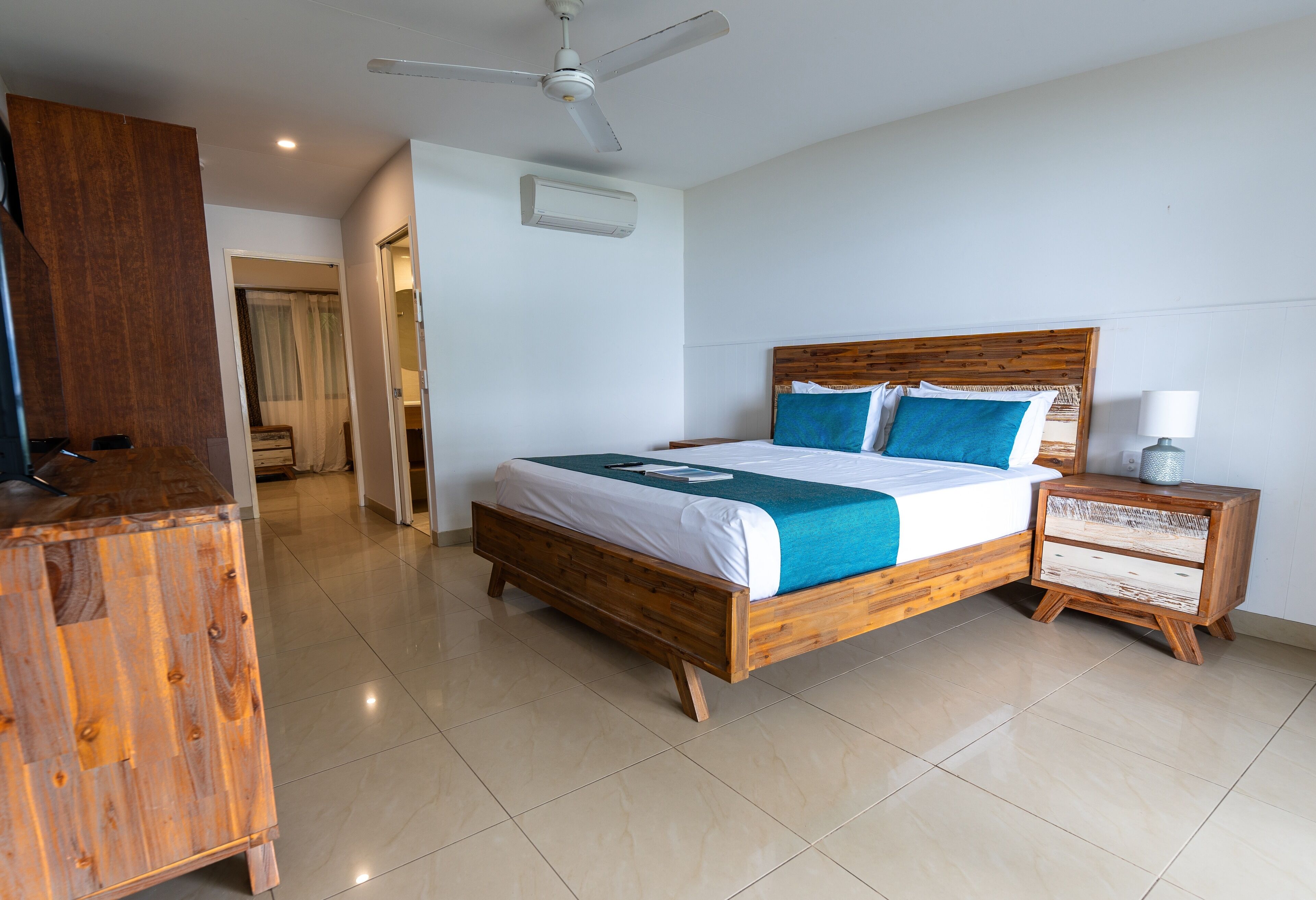 A bedroom with a wooden bed, a nightstand, a ceiling fan, and a wardrobe.