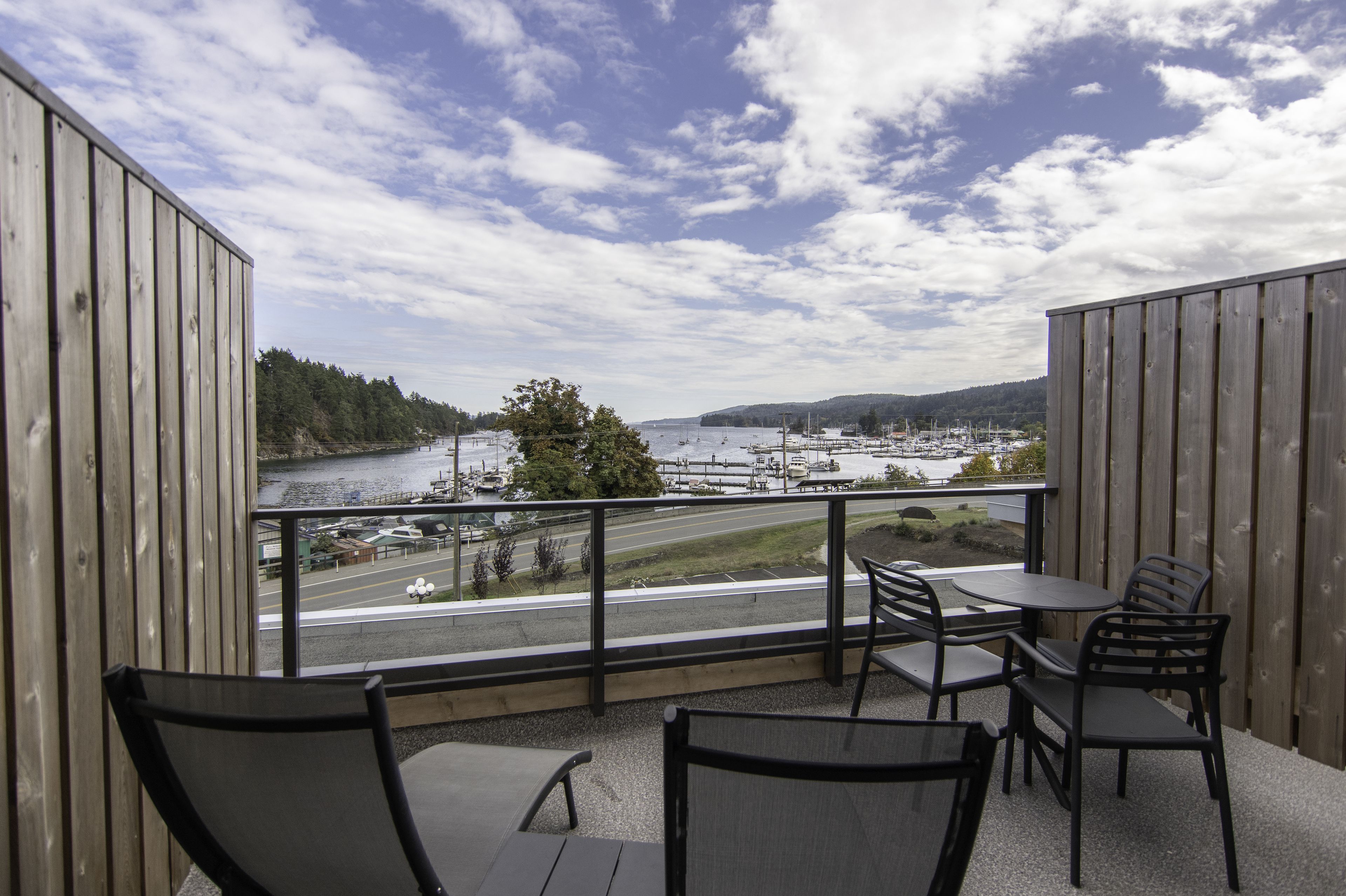 A balcony with a view of a marina and a road.