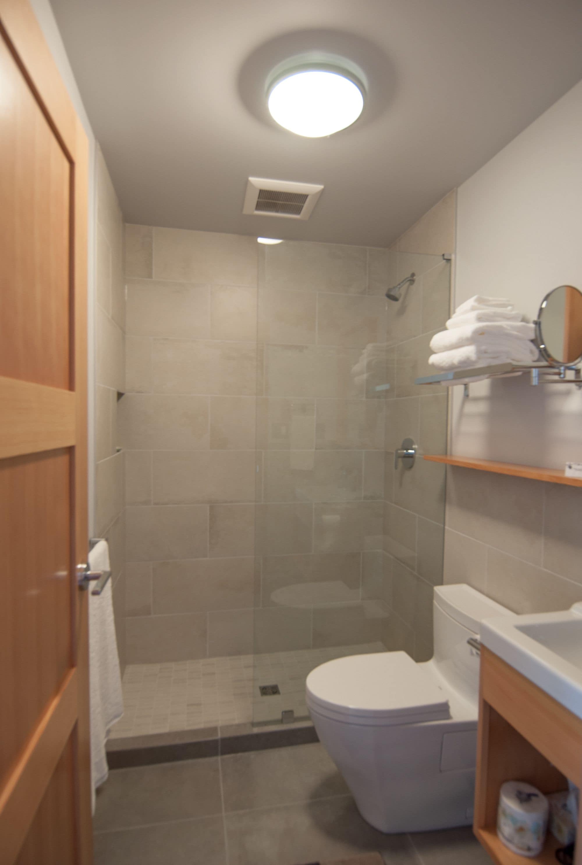A bathroom with a shower, toilet, and a sink.