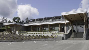 A modern building with a flat roof, large windows, and a covered entrance area.