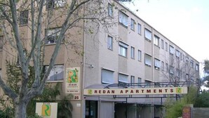 A building labeled "REDAN APARTMENTS" with a sign indicating the number 25. - H&D Apartments (St Kilda)