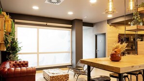 Una sala de estar moderna con un sofá de cuero, una mesa de centro de madera y un comedor con una mesa y sillas de madera.