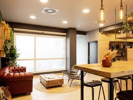 Una sala de estar moderna con un sofá de cuero, una mesa de centro de madera y un comedor con una mesa y sillas de madera.