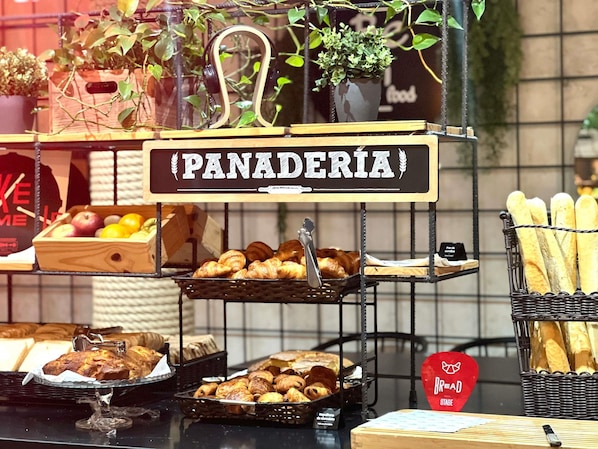 A bakery display with pastries, bread, and fruits.