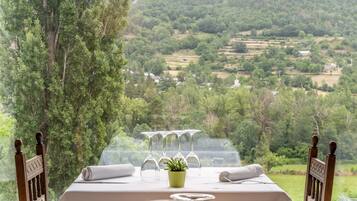 Une table dressée pour le dîner, avec vue sur un paysage luxuriant.