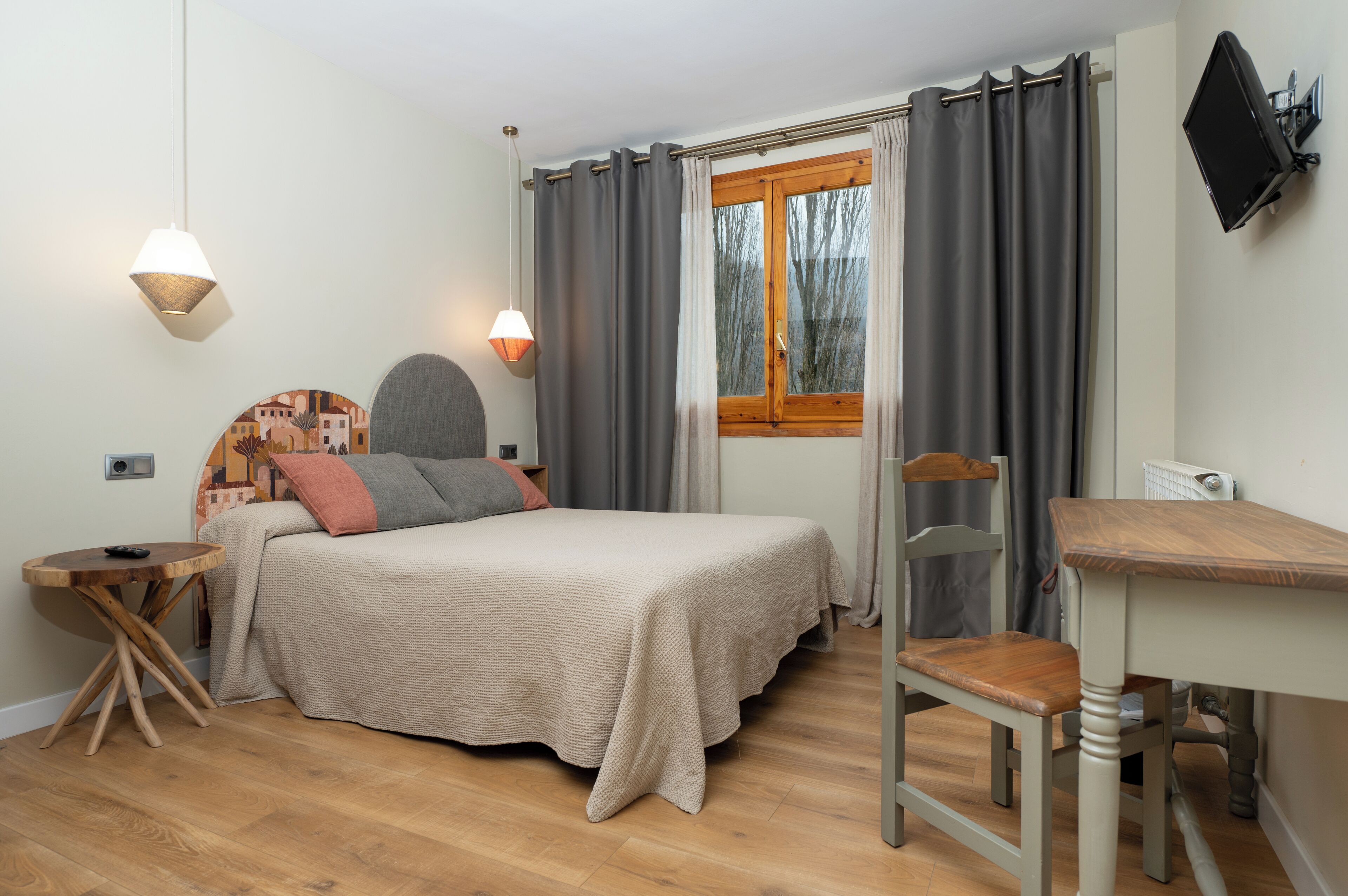 Un dormitorio con cama, mesita de noche, silla y escritorio.