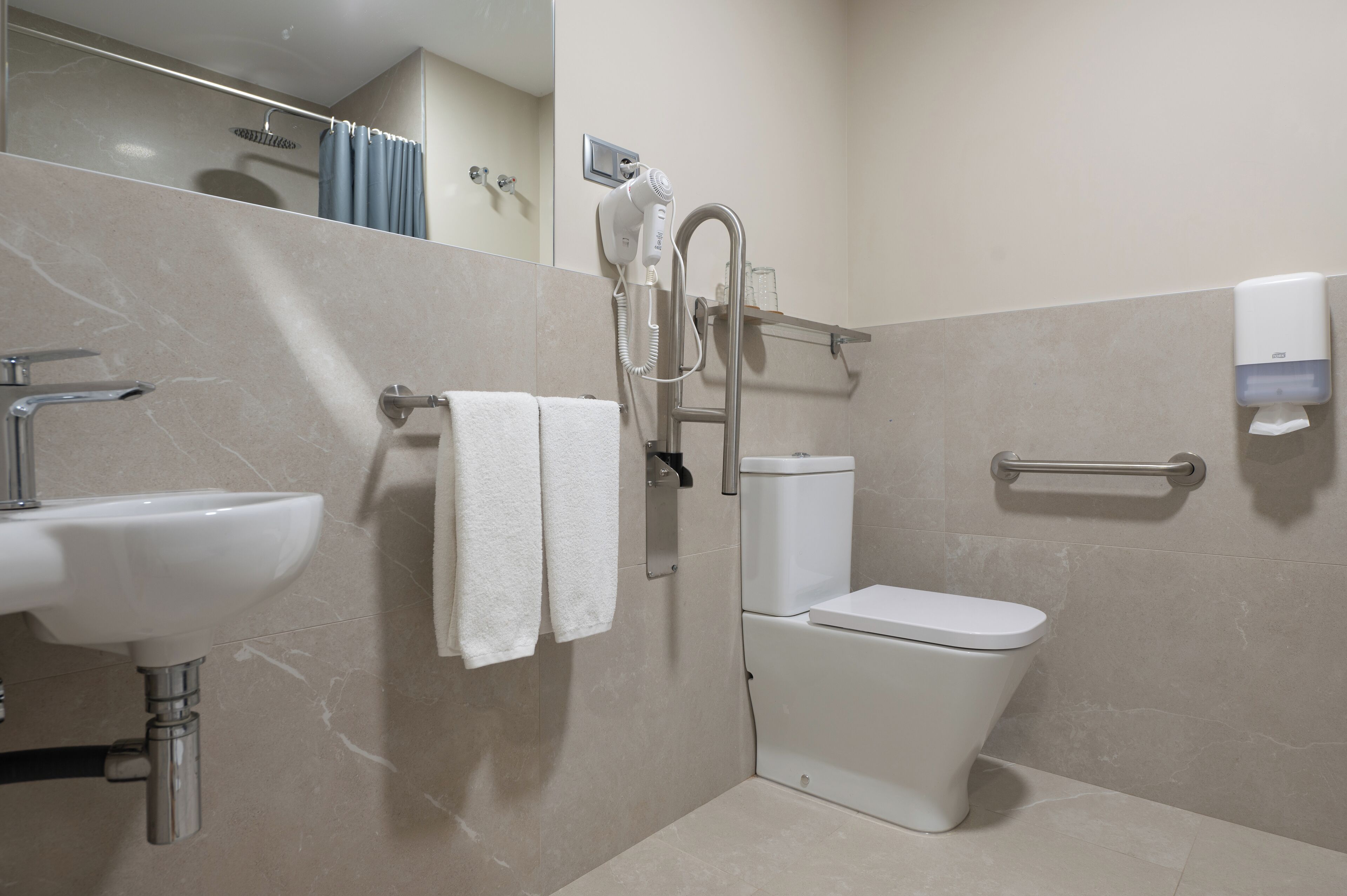 A modern bathroom with a sink, toilet, and shower.