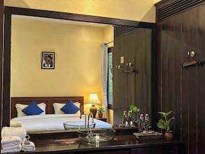 A hotel room with a bed, a bedside table with a lamp, a mirror, and a wardrobe. - Inthira Thakhek (Thakhek)