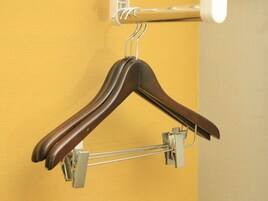 Un perchero de madera sujeto a la pared con un sujetador de metal.