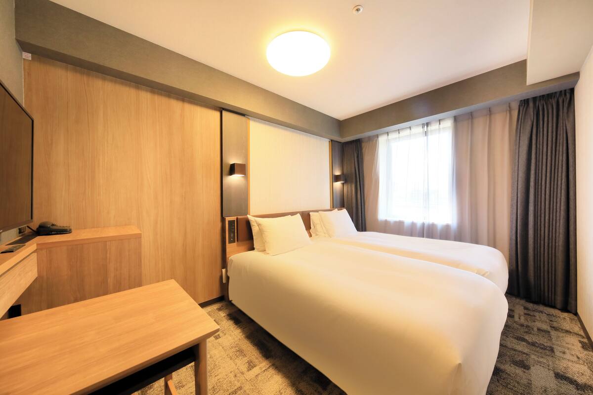 Une chambre d’hôtel avec un grand lit, un bureau et une armoire.