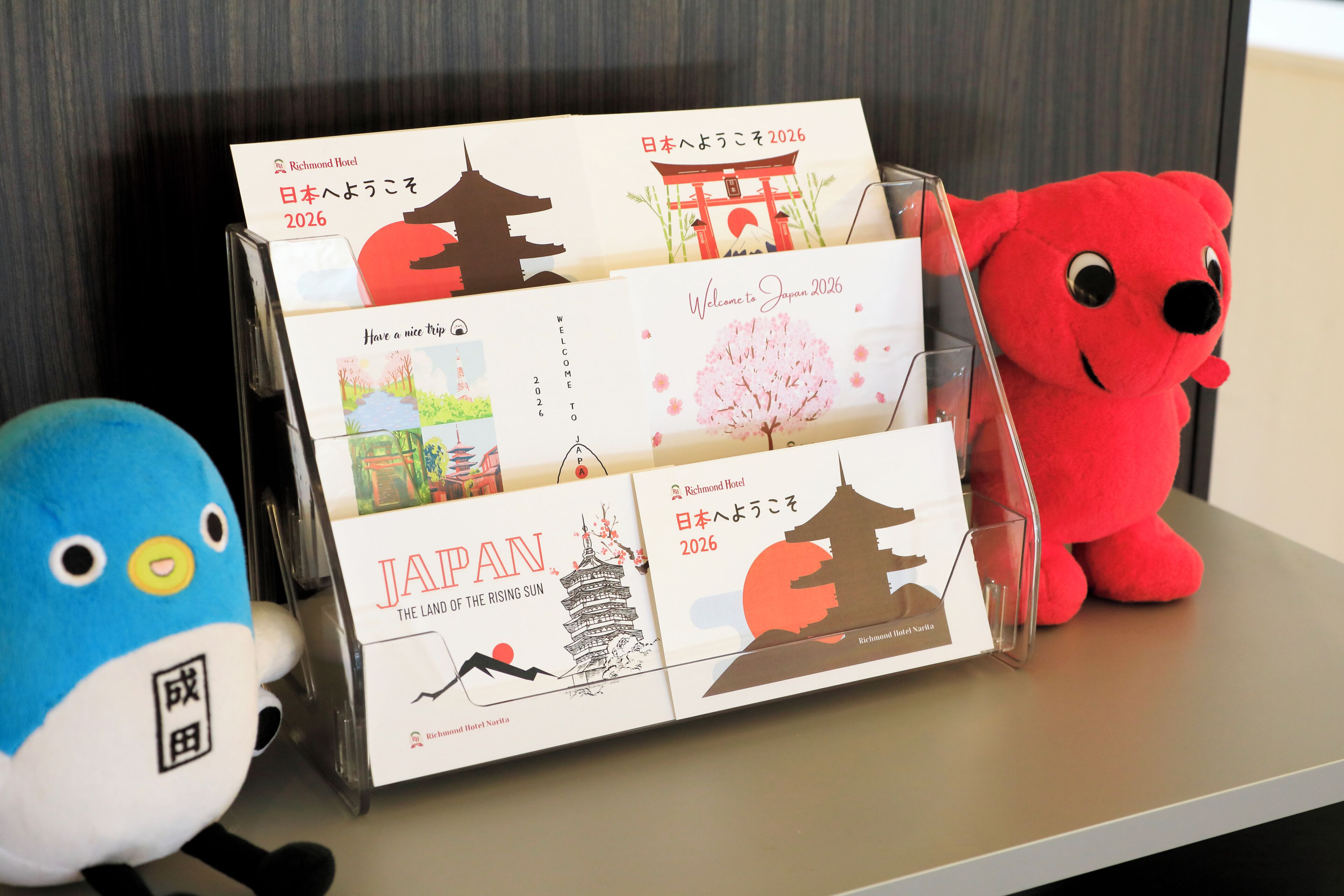 A display of travel brochures and a plush toy on a shelf.