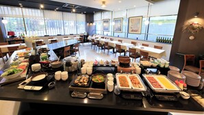 Un buffet proposant une variété de plats et un espace repas avec des tables et des chaises.