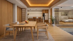 Un intérieur moderne avec une table à manger en bois, des chaises, un panier de fruits et un coin cuisine.
