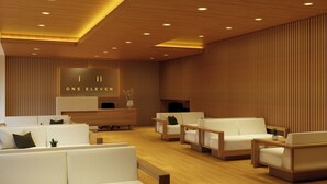 En modern hotellobby med en receptionsdisk, en sittgrupp och träpanel.
