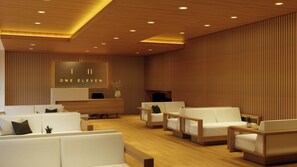 Un moderno vestíbulo de hotel con mostrador de recepción, zona de estar y paneles de madera.