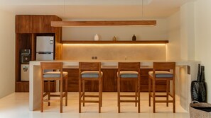 A modern kitchen with a central island, wooden cabinets, and a built-in refrigerator. - One Eleven Haven (Keroboken Kelod)