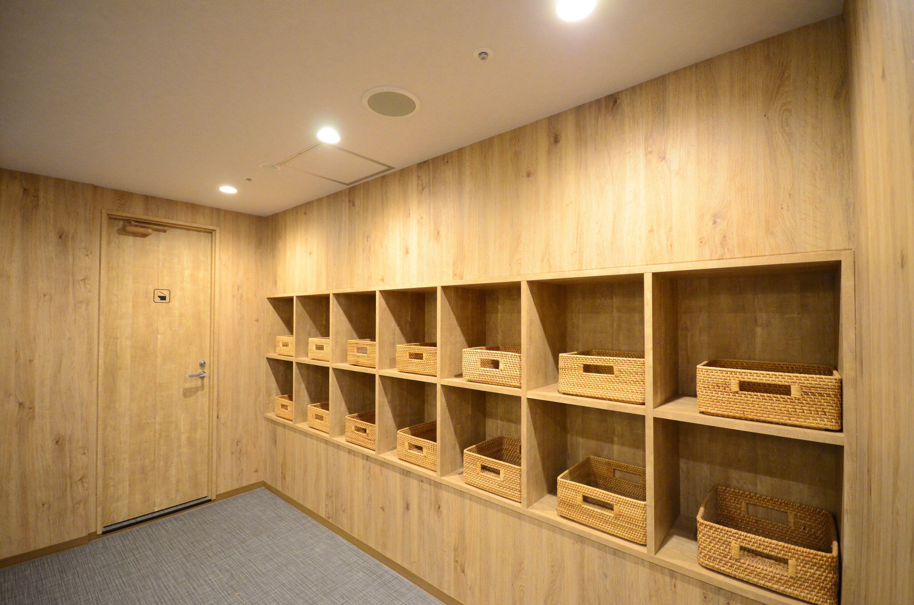 A room with wooden walls and shelves containing baskets.