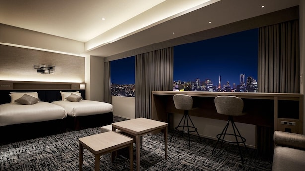 A hotel room with two beds, a desk with two chairs, a small table, and a city view. - Lotte City Hotel Kinshicho (Tokyo)