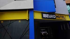 Un bâtiment d'hôtel avec une enseigne verticale bien visible portant l'inscription « IBEURO HOTEL ».