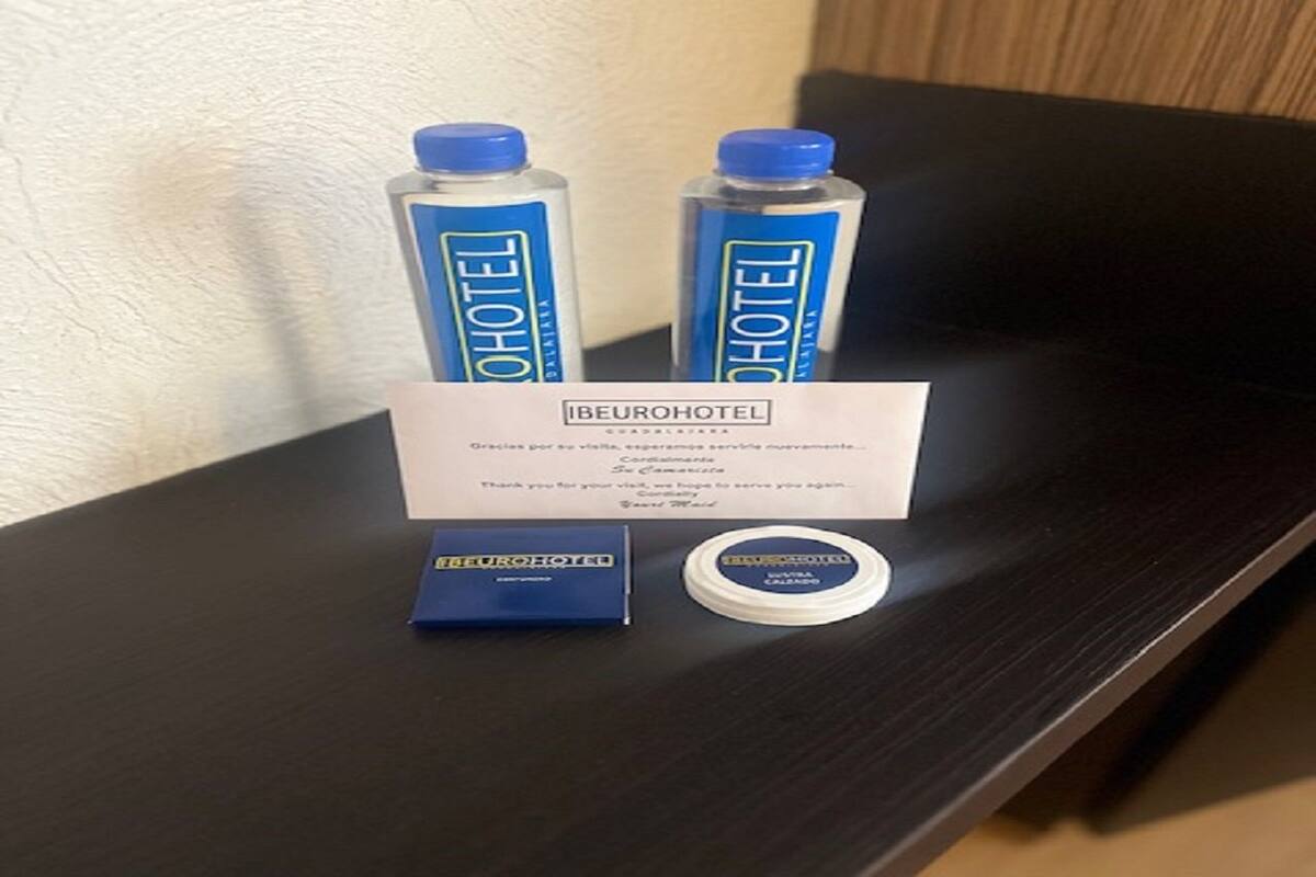 Un mini-bar d’hôtel comprenant deux bouteilles d’eau, un plateau pour mini-bar et une carte.