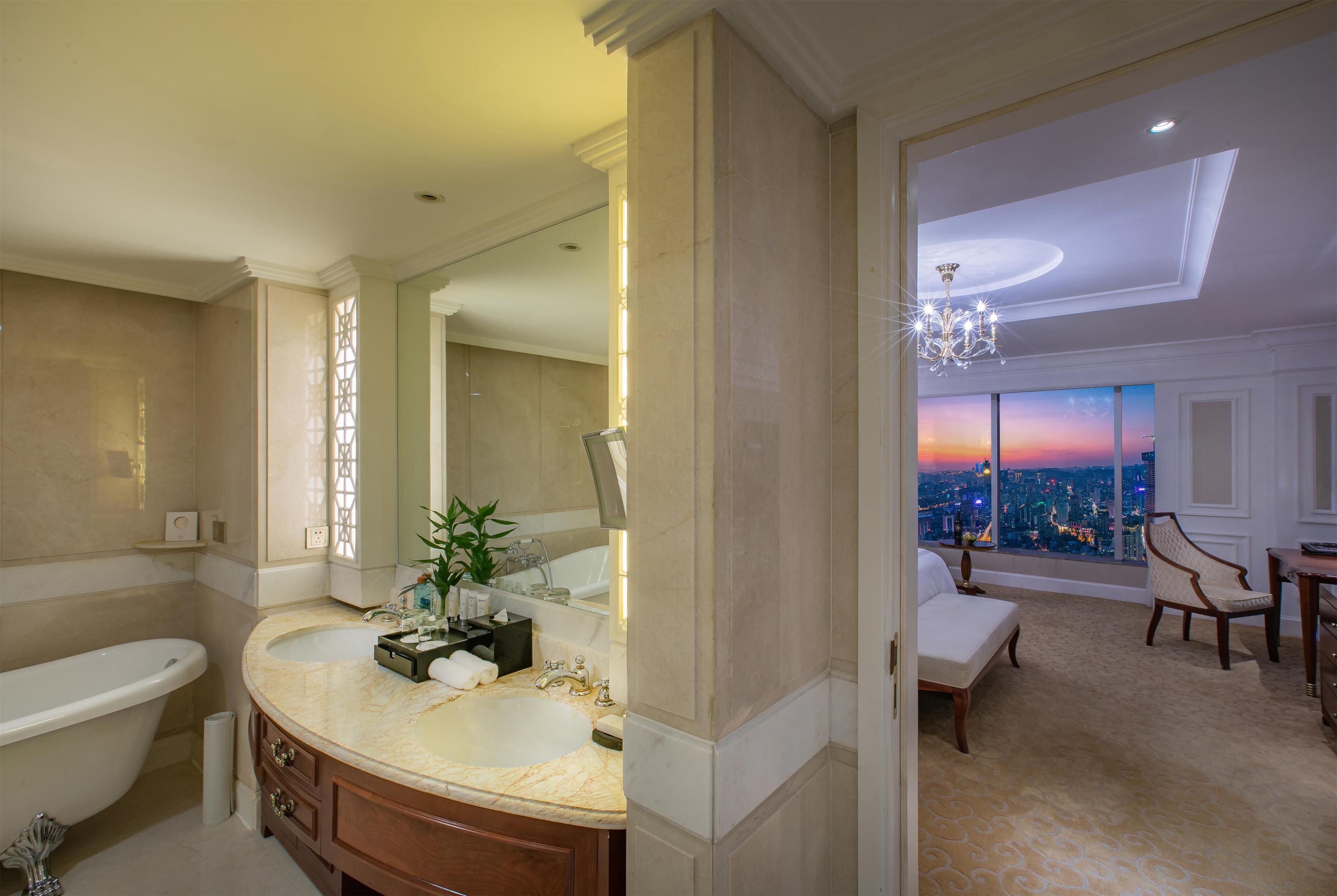A luxurious bathroom with a double sink vanity, a bathtub, and a large mirror.
