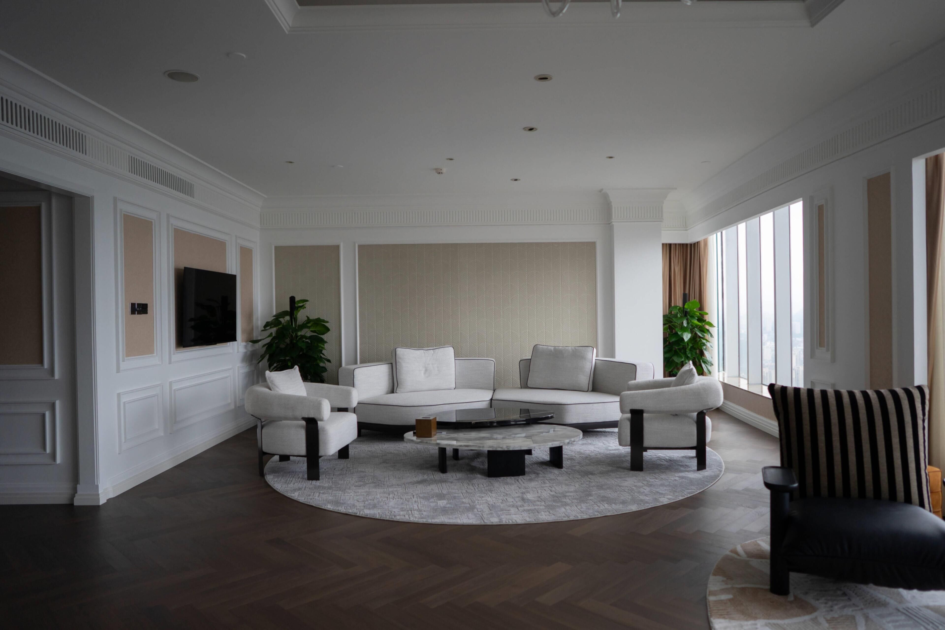A modern living room with a sectional sofa, a coffee table, and a striped armchair.