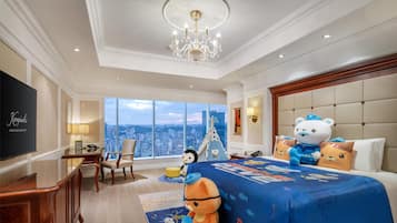A hotel room with a large bed, a television, a desk, and a view of the city.