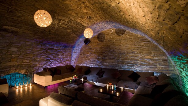 A cozy lounge area with stone walls, a stone bench, and a sofa. - Optima Collection Kamianets-Podilskyi (Kamianets-Podilskyi)