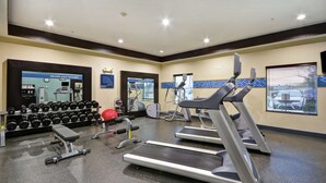 Ein Fitnessstudio mit Laufbändern, Hanteln und Trainingsgeräten.