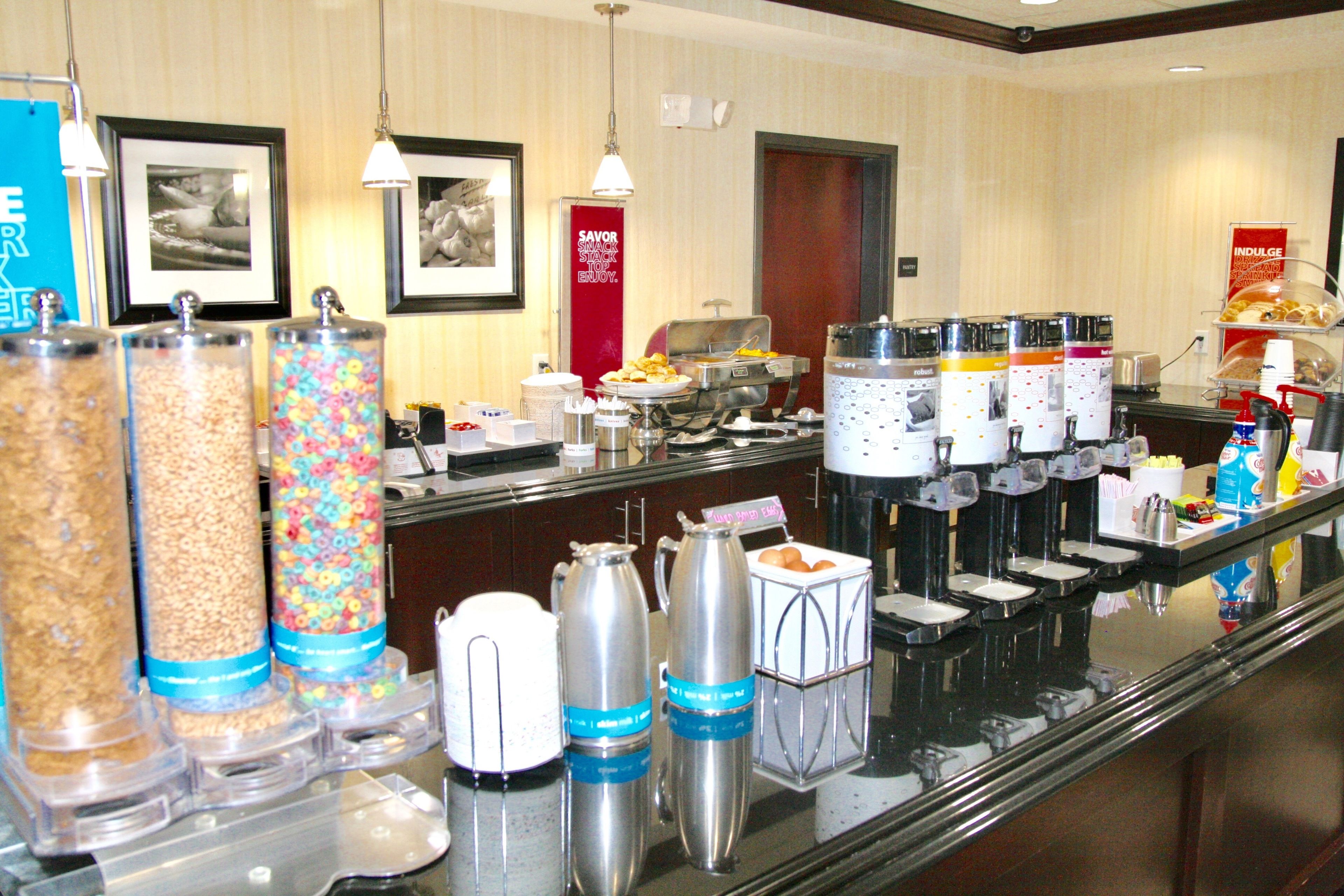 Montaje de bufé con varios recipientes de comida y dispensadores de café.