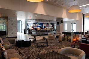 A modern lounge area with a bar, comfortable seating, and a fireplace.