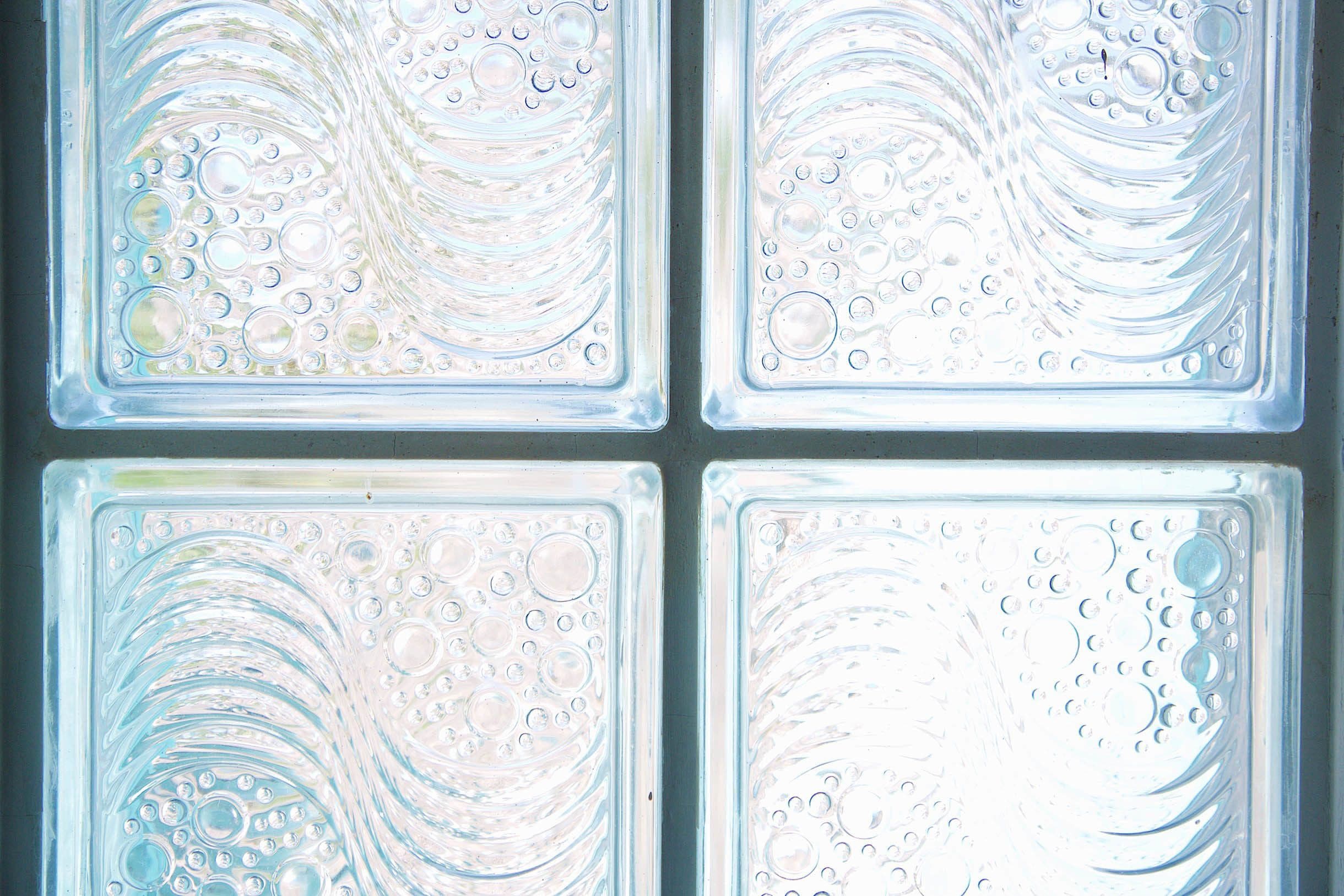 A frosted glass window with a wavy pattern and bubbles.