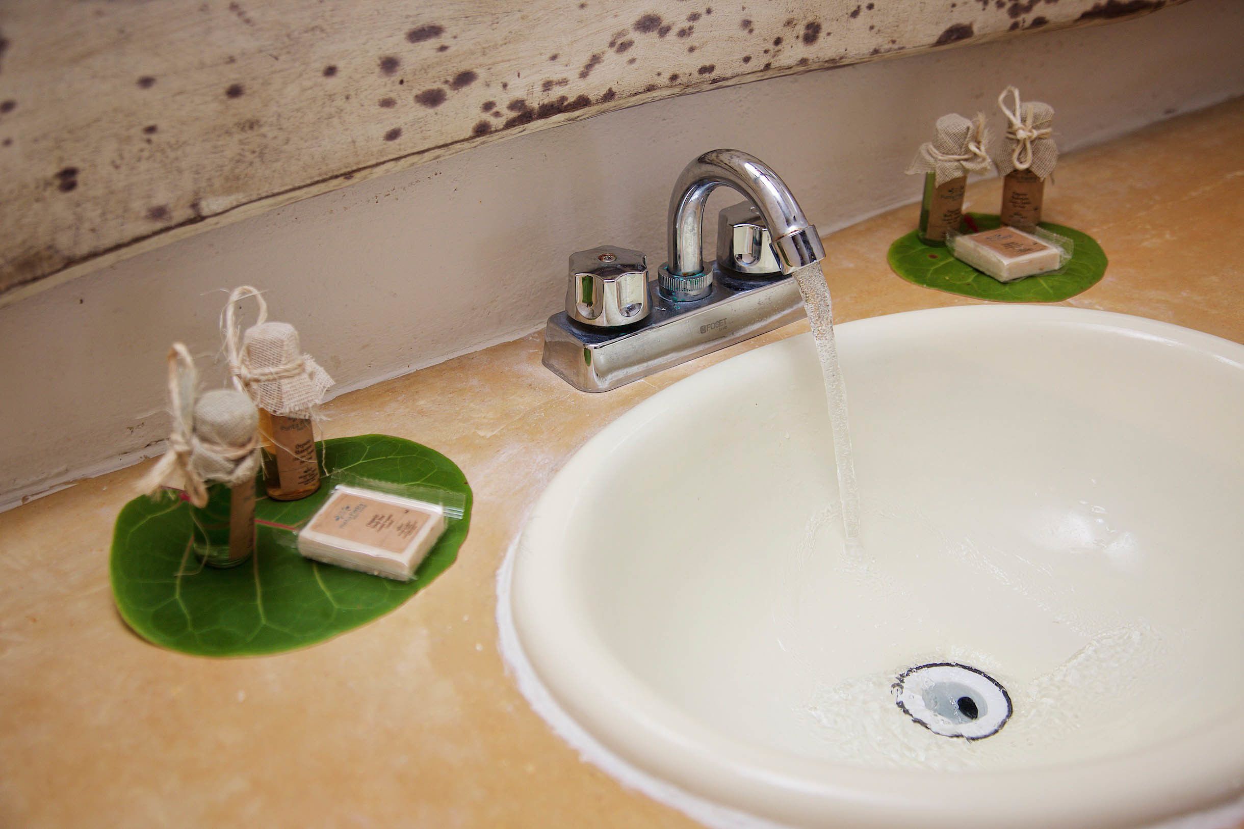 Uma pia de banheiro com uma torneira, sabonete e um porta-sabonete decorativo.