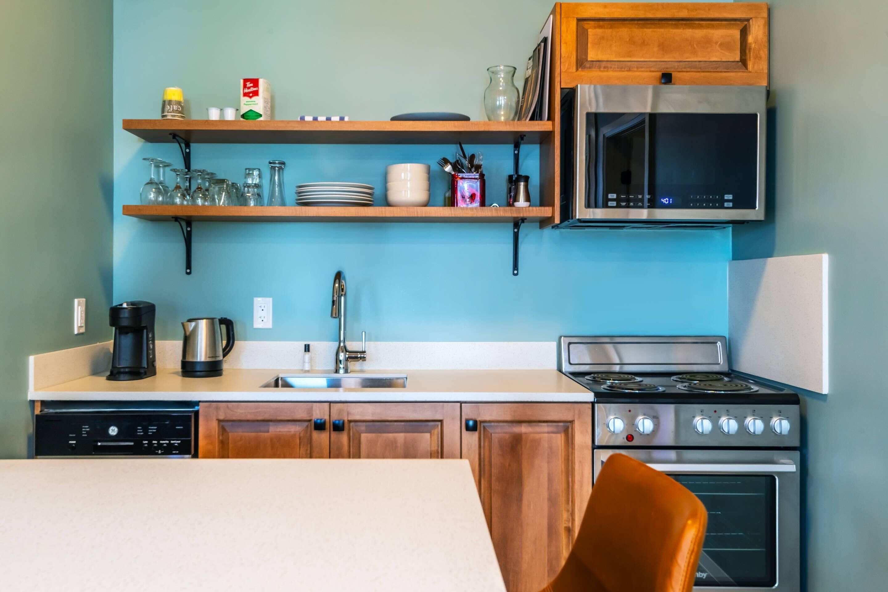 A kitchen with wooden cabinets, a microwave, a stove, and a dishwasher.