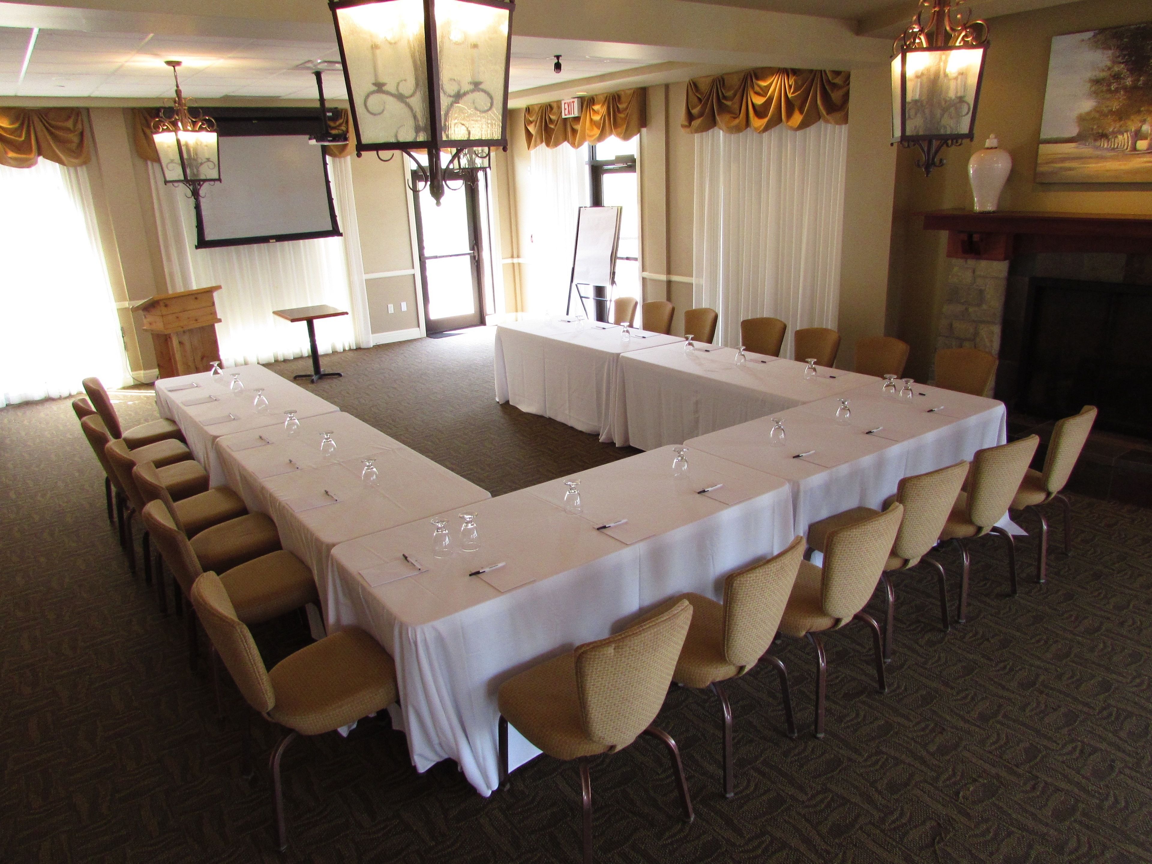 A conference room with a long table, chairs, and a fireplace.