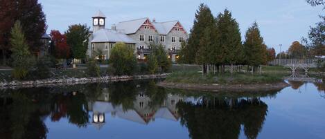 A large, historic building with a tower, reflecting in a calm body of water.