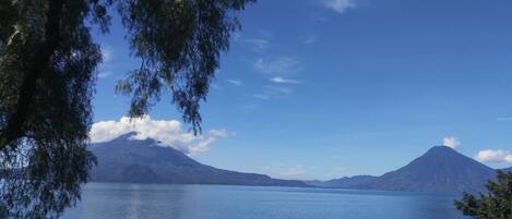 A calm lake with boats, surrounded by mountains and trees.