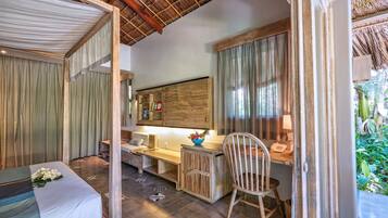 Una habitación con cama, escritorio, silla, espejo y ventana con cortinas.
