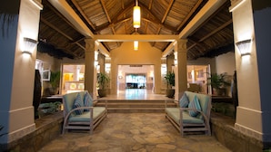 A lobby with a thatched roof, stone flooring, and two armchairs with cushions. - Sailing Club Resort Mui Ne (Mui Ne)
