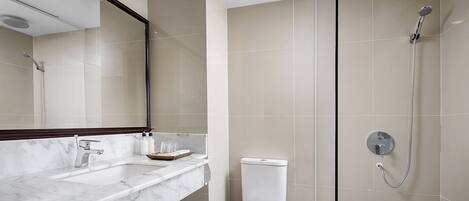 Ein modernes Badezimmer mit einem мраморным Waschbecken, einer Toilette und einer Dusche mit Duschbrause.