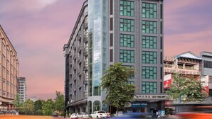 A modern hotel with a glass facade, multiple floors, and a visible sign for a seat shop. - New York Hotel (Phnom Penh)